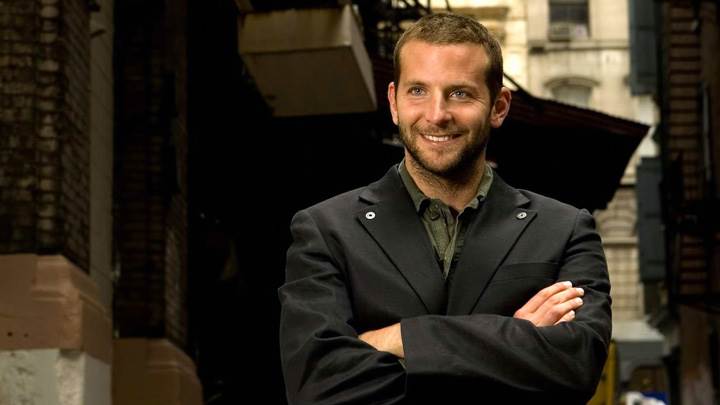 Bradley Cooper Smiling In Black Coat Outside Building